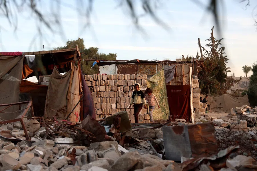 Children walk past shelters at a makeshift camp for displaced Palestinians in the Nahr al-Bared area in Khan Yunis, in the southern Gaza Strip on 9 December 2024, amid the continuing war between Israel and the militant Hamas group. (Bashar Taleb/AFP)
