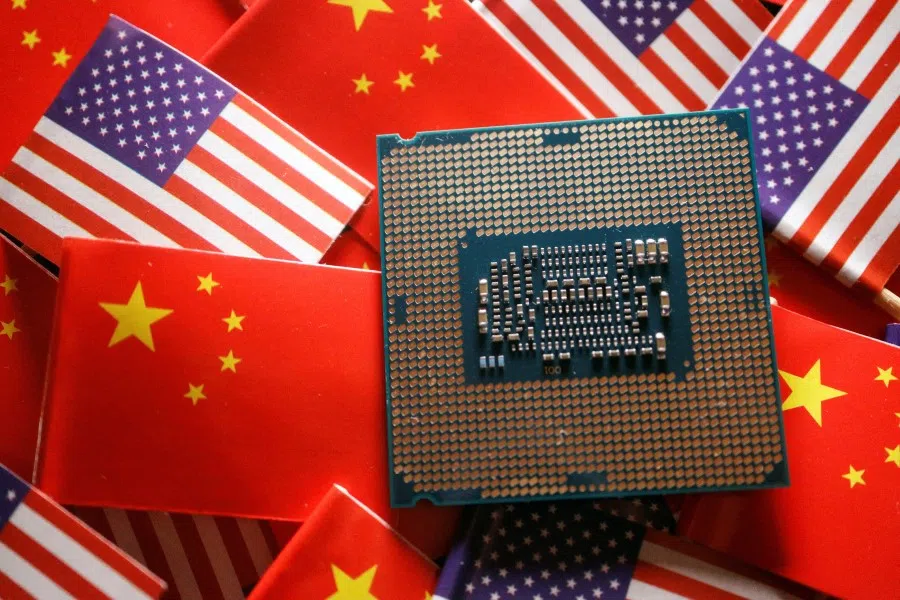 A central processing unit (CPU) semiconductor chip is displayed among flags of China and U.S., in this illustration picture taken 17 February 2023. (Florence Lo/Reuters)