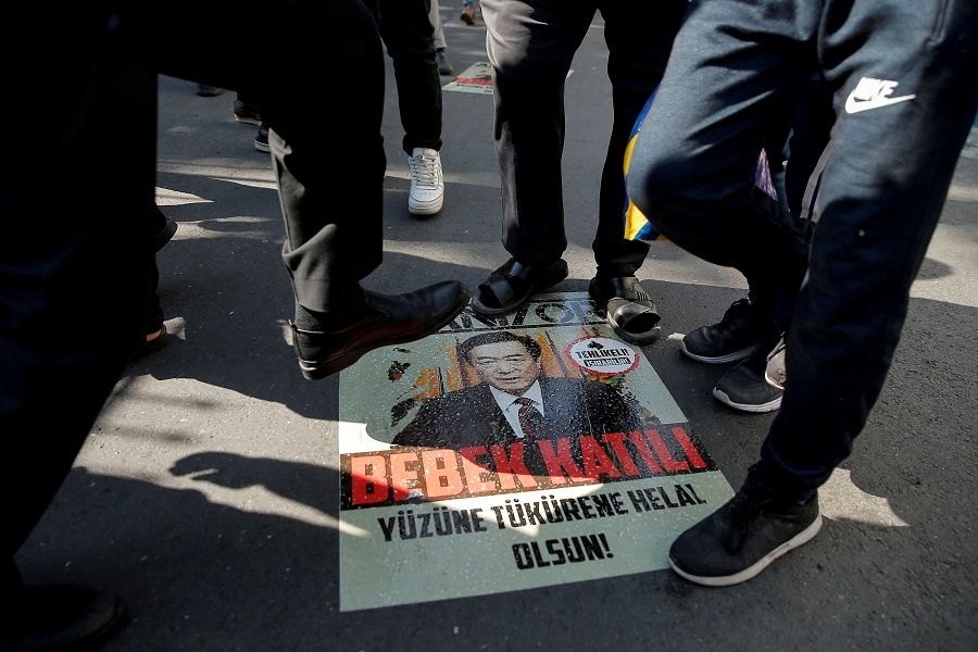 Ethnic Uighur demonstrators step on a poster with an image of Communist Party Secretary of Xinjiang Uyghur Autonomous Region Chen Quanguo, during a protest against China in front of the Chinese Consulate in Istanbul, Turkey, on 1 October 2019. (Huseyin Aldemir/File Photo/Reuters)