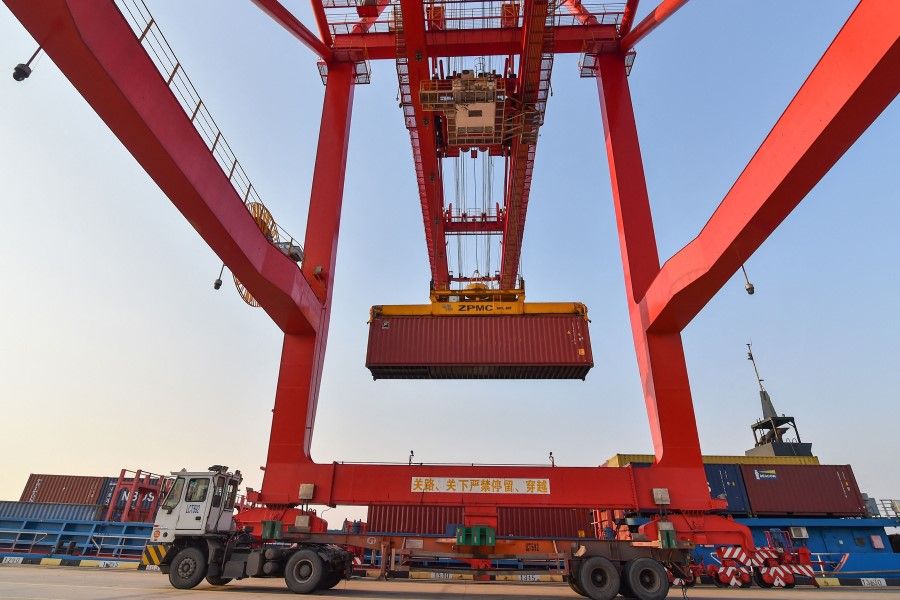 This photo taken on 3 January 2023 shows a crane loading a container at Nanjing port in China's eastern Jiangsu province. (AFP)