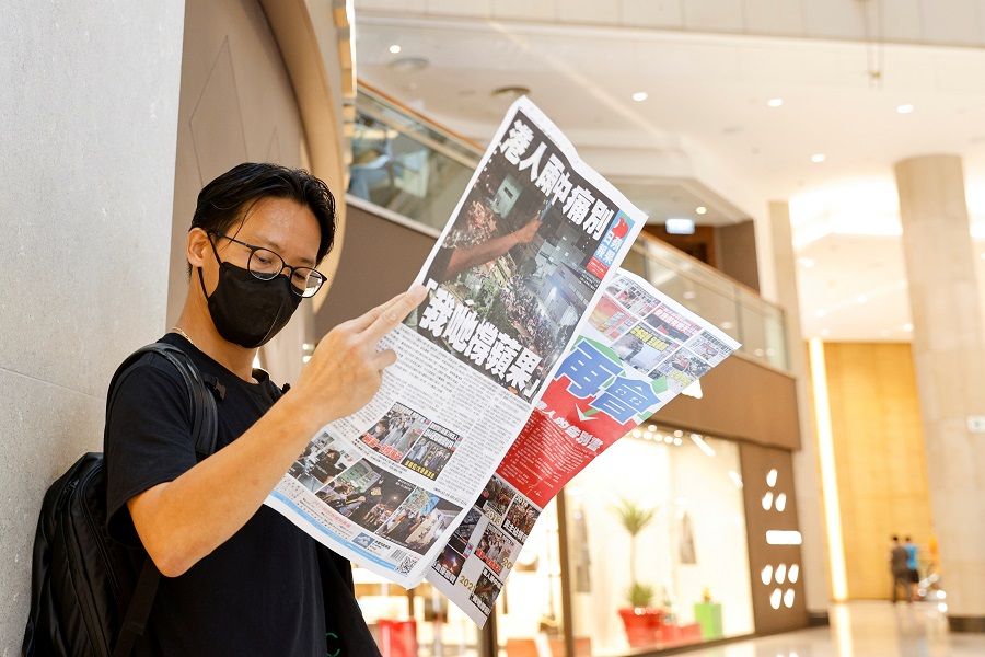 An Apple Daily supporter reads the final edition of the newspaper at a shopping mall in Hong Kong on 24 June 2021. (Tyrone Siu/File Photo/Reuters)