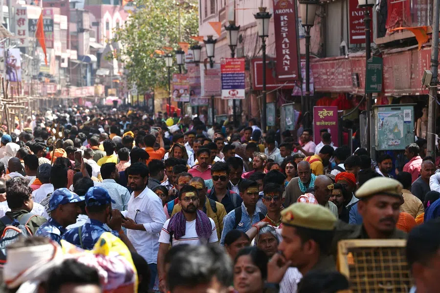 People walk along a crowded market area in Varanasi, India, on 8 March 2024. (Niharika Kulkarni/AFP)