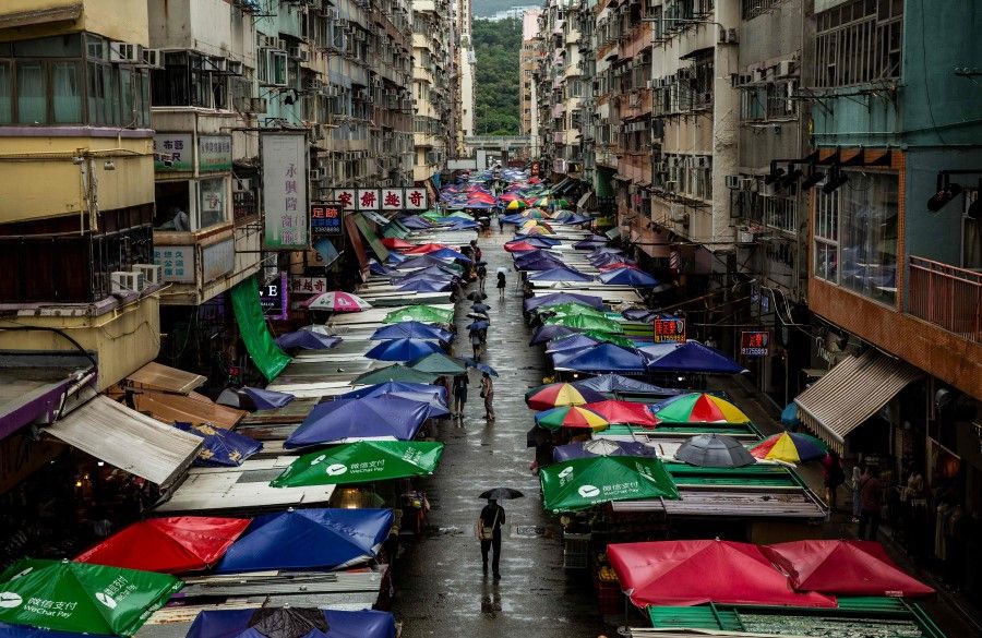 People walk through the markets in the Mong Kok district of Hong Kong on 13 August 2021. (Isaac Lawrence/AFP)