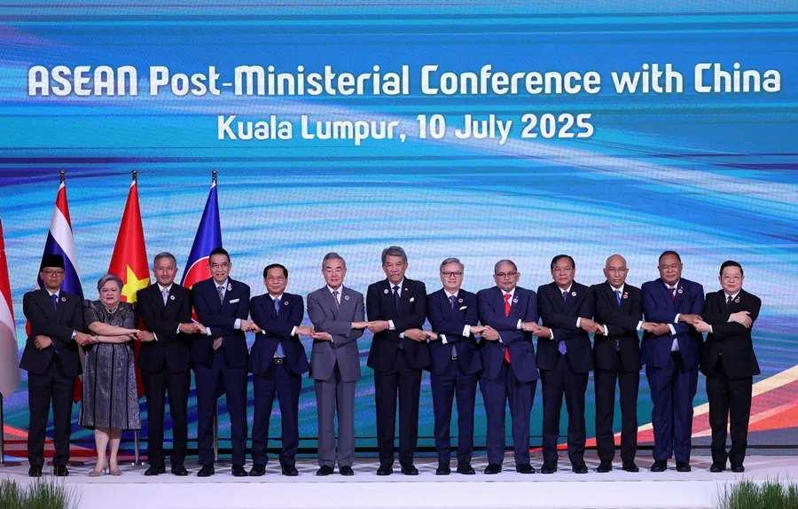 ASEAN foreign ministers and Chinese foreign minister Wang Yi join hands for a group photo during ASEAN Post-Ministerial Conference with China at the Kuala Lumpur Convention Centre in Kuala Lumpur, Malaysia, on 10 July 2025.