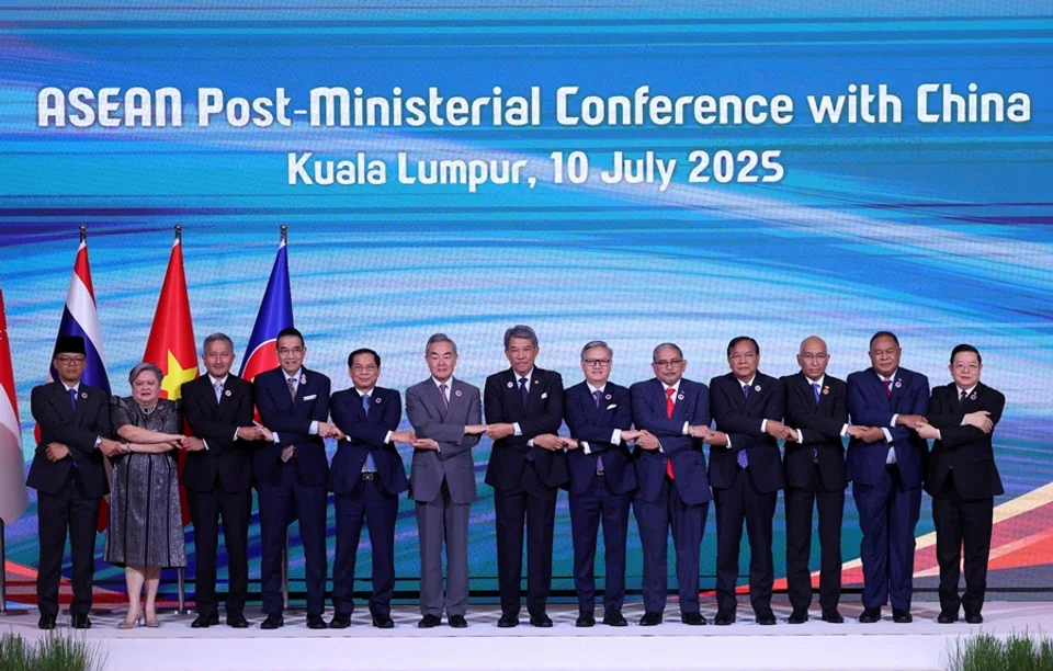 ASEAN foreign ministers and Chinese foreign minister Wang Yi join hands for a group photo during ASEAN Post-Ministerial Conference with China at the Kuala Lumpur Convention Centre in Kuala Lumpur, Malaysia, on 10 July 2025. (Hasnoor Hussain/Reuters)