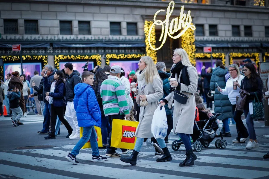 People carry shopping bags in New York on 8 December 2024. (Kena Betancur/AFP)