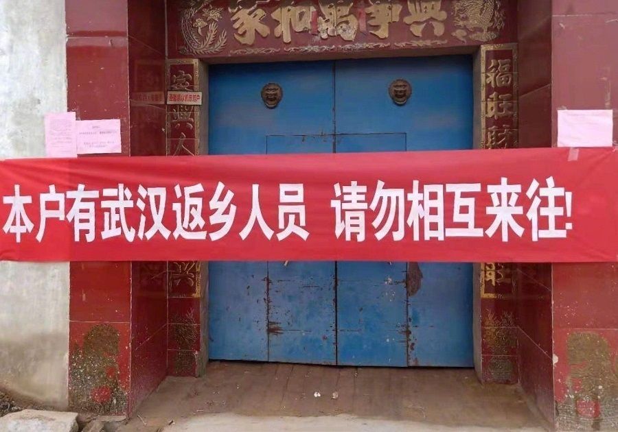 This banner spread across a residential home reads: "Wuhan people who've returned to their home provinces are in this house. No interactions allowed, please."