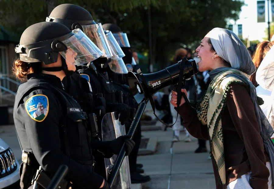 A pro-Palestinian protestor faces off with Wayne State University (WSU) police after the WSU student encampment was raided by WSU police in Detroit, Michigan, US, on 30 May 2024. (Rebecca Cook/Reuters)
