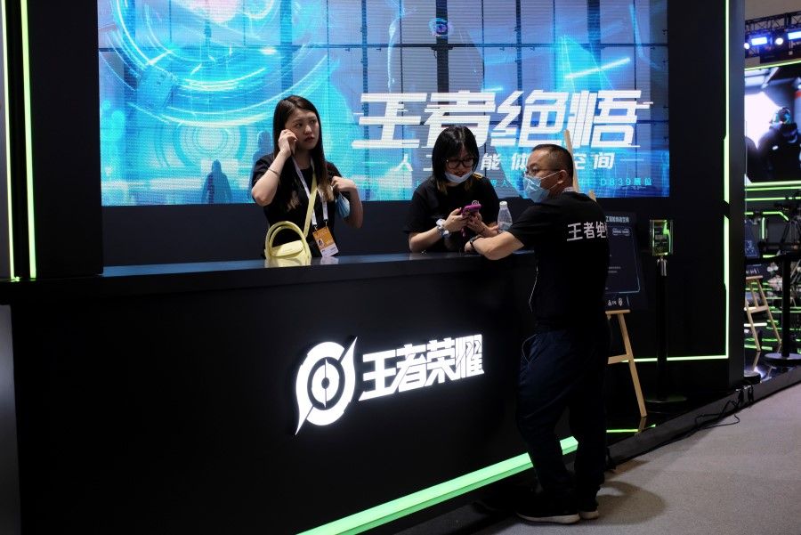 Staff members stand at the booth of Honor of Kings, a Tencent Games game, during the World Artificial Intelligence Conference (WAIC) in Shanghai, China, 8 July 2021. (Yilei Sun/Reuters)