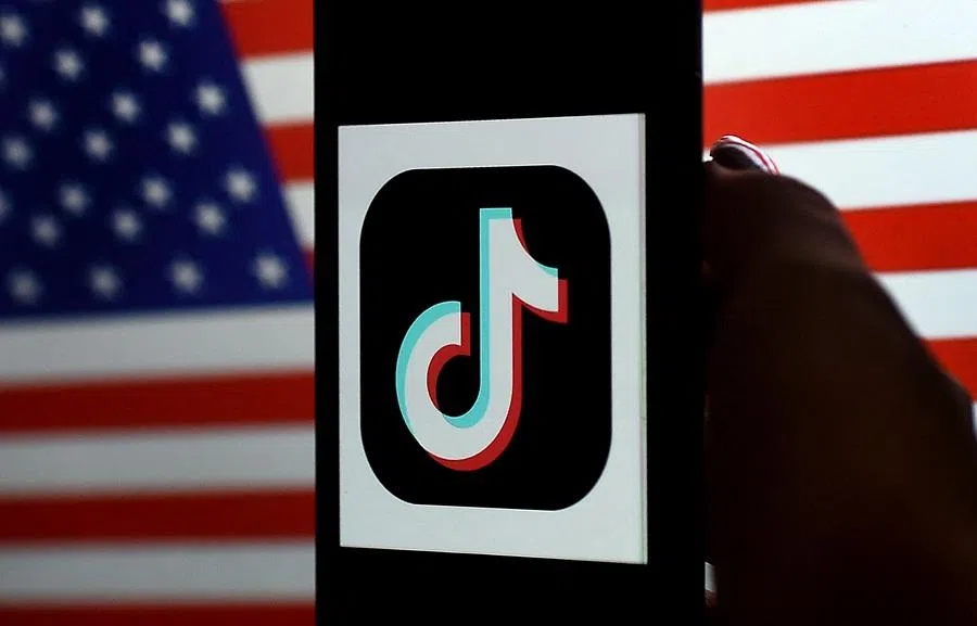In this photo illustration, the social media application logo TikTok is displayed on the screen of an iPhone on a US flag background on 3 August 2020 in Arlington, Virginia.
