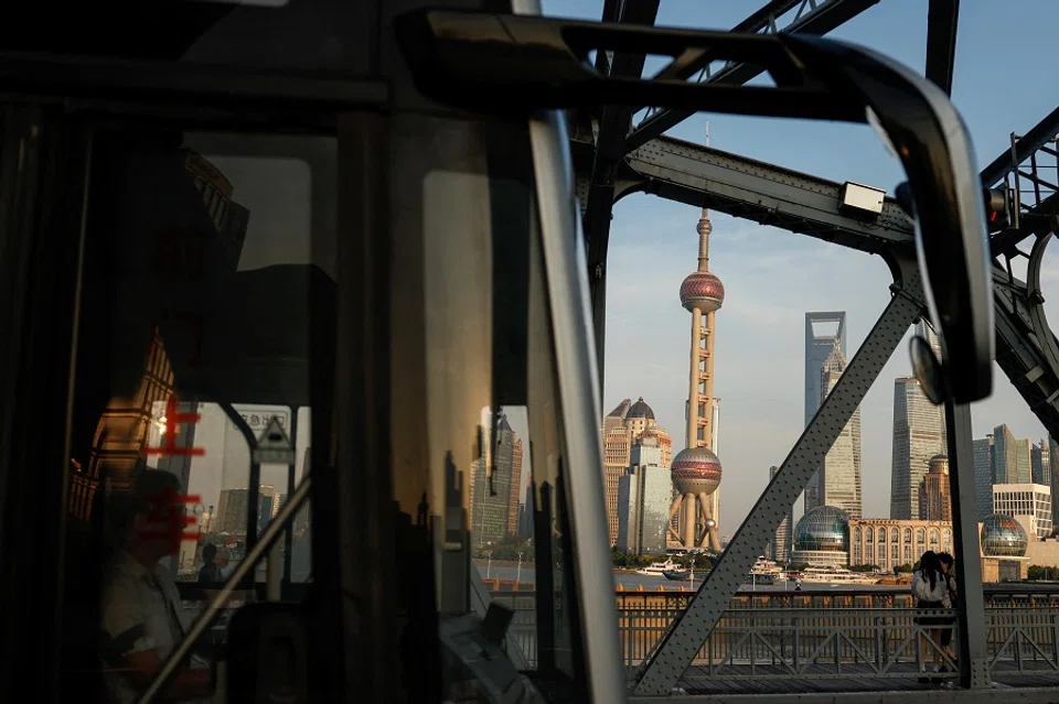 A bus moves past a bridge with the backdrop of the financial district of Pudong in Shanghai, China, on 27 September 2024. (Tingshu Wang/Reuters)