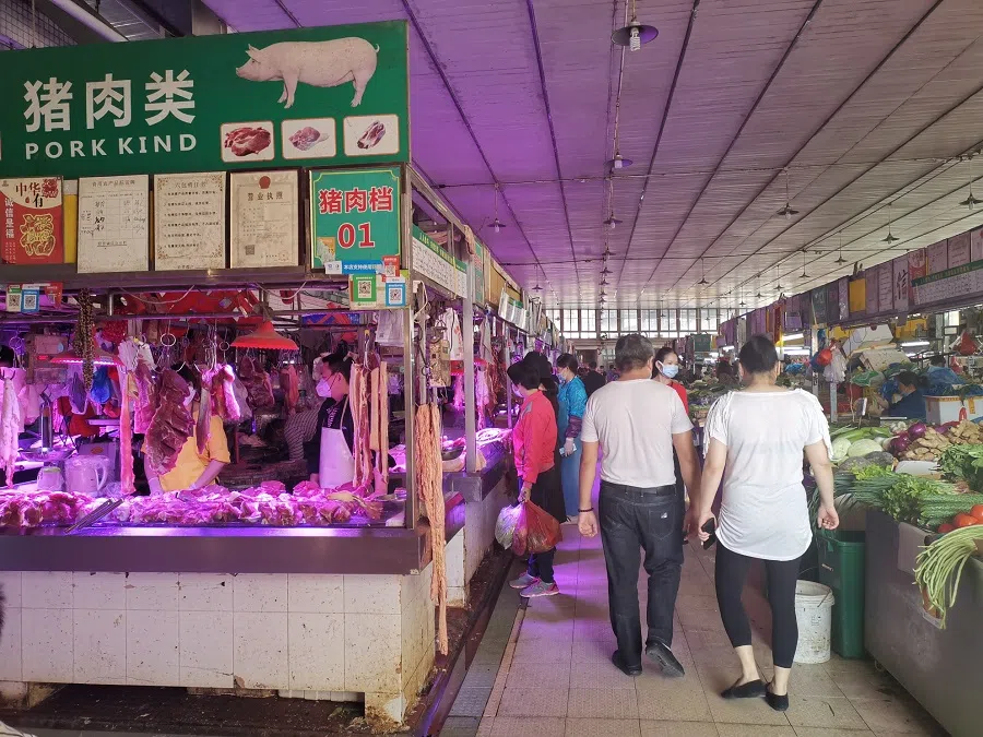 Information boards detailing stall numbers, product descriptions, prices and so on, hang above stalls in Longdong Market.