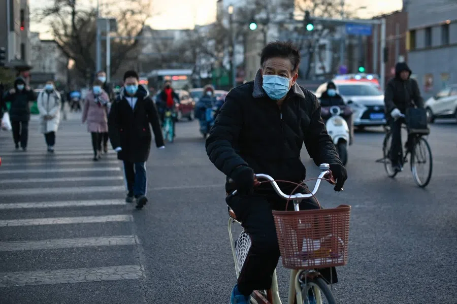 An elderly man riding his bicycle crosses a street in Beijing on 4 January 2021. (Wang Zhao/AFP)