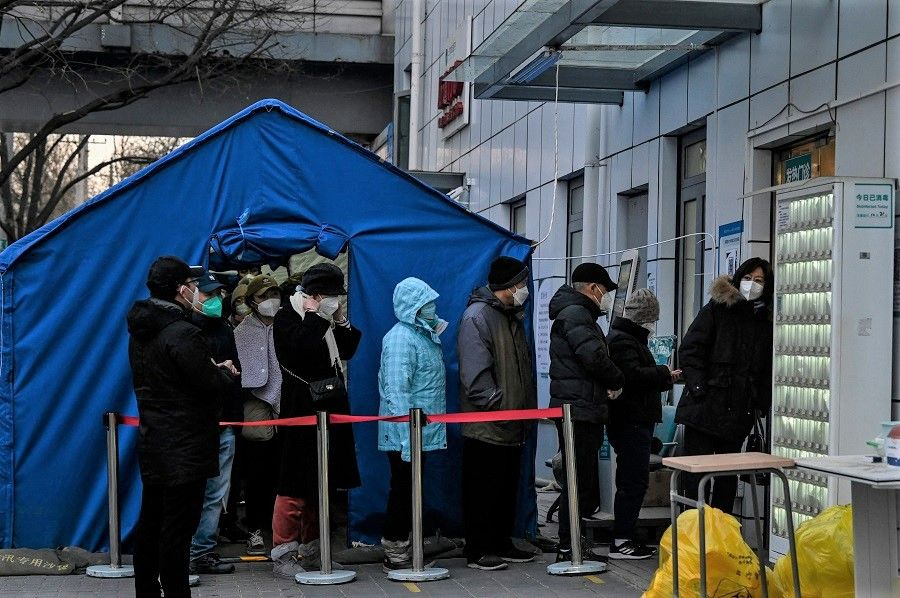 People wait in a line outside a fever clinic at a hospital amid the Covid-19 pandemic in Beijing, China, on 21 December 2022. (Jade Gao/AFP)