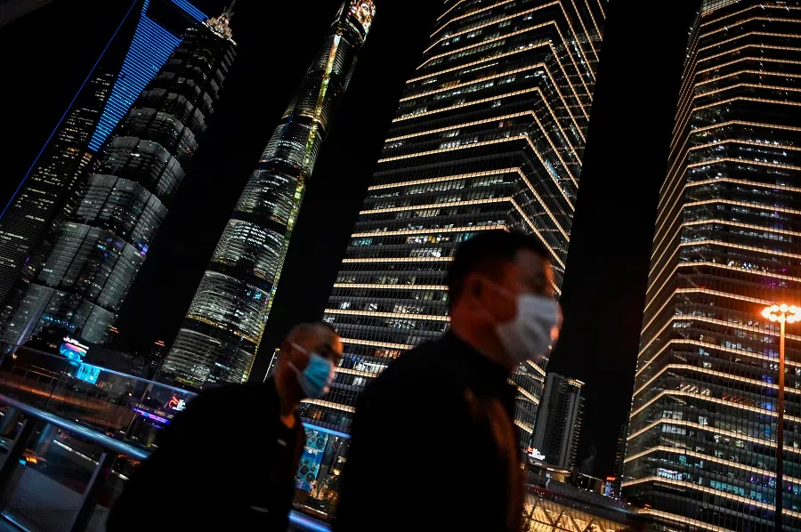 People wearing face masks as a preventive measure against the Covid-19 coronavirus walk along a path in the financial district of Lujiazui in Shanghai on 9 November 2020. (Hector Retamal/AFP)
