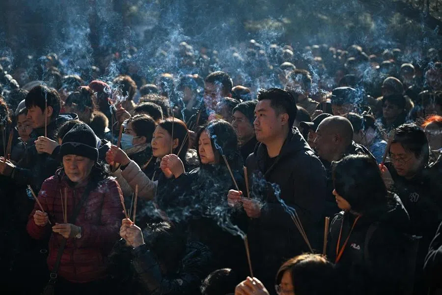 People burn incense as they pray at the Lama Temple in Beijing on 17 February 2026. (Adek Berry/AFP)