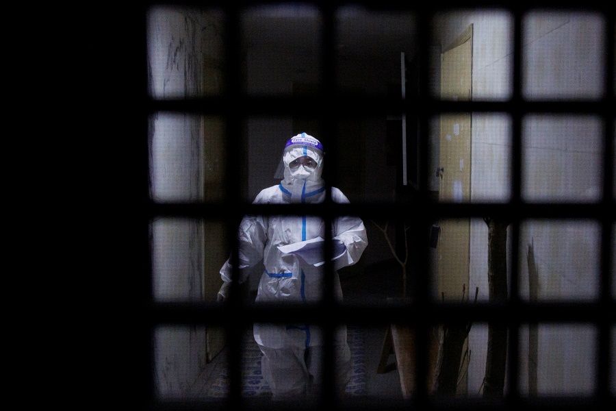 A pandemic prevention worker in a protective suit approaches an apartment in a building that went into lockdown as Covid-19 outbreaks continue in Beijing, China, 2 December 2022. (Thomas Peter/Reuters)