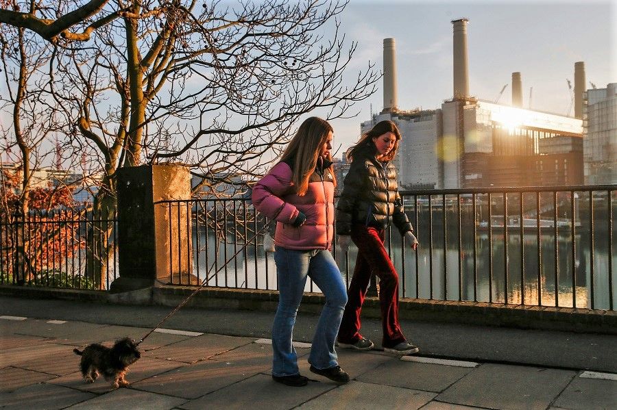 Pedestrians walk along the banks of the River Thames in view of the Battersea Power Station office, retail and residential development in the Nine Elms district in London, UK, 7 January 2021. (Hollie Adams/Bloomberg)