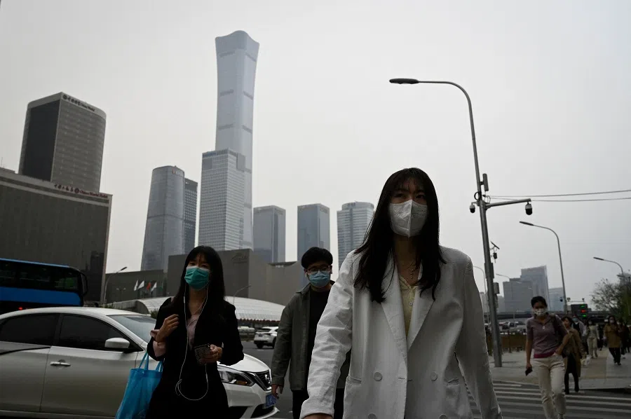 People commute at the central business district in Beijing, China, on 21 April 2022. (Jade Gao/AFP)
