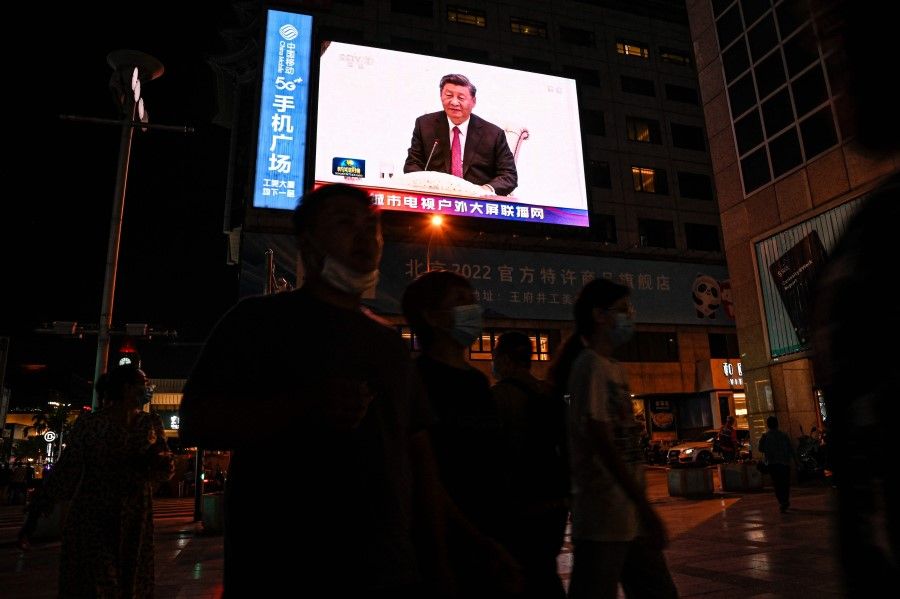 An outdoor screen shows a news programme about China's President Xi Jinping attending a meeting with Uzbek President Shavkat Mirziyoyev on the sidelines of the Shanghai Cooperation Organisation (SCO) leaders' summit in Samarkand, in Beijing on 15 September 2022. (Jade Gao/AFP)