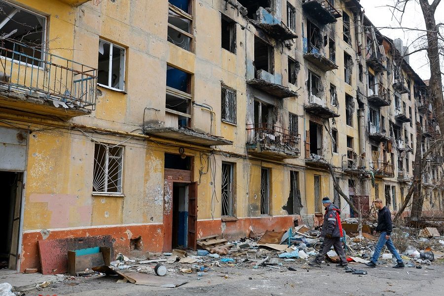 Men approach a multi-storey apartment block, which was destroyed in the course of the Russia-Ukraine conflict, in Mariupol, Russian-controlled Ukraine, 16 March 2023. (Alexander Ermochenko/Reuters)
