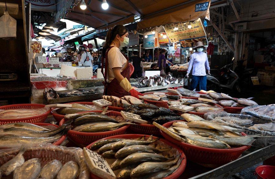A fish vendor waits for customers at a market in Taipei, Taiwan, on 12 August 2022. (Asnaya Chou/AFP)