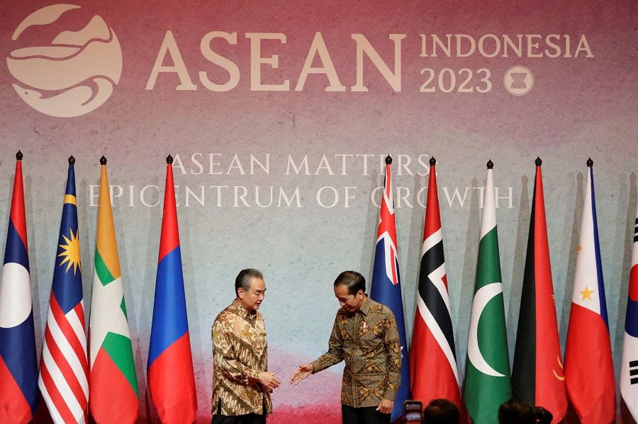 Indonesia's President Joko Widodo greets Director of the Office of the Foreign Affairs Commission of the Communist Party of China's Central Committee Wang Yi (left) during the courtesy call at the Association of Southeast Asian Nations (ASEAN) Foreign Ministers' Meeting in Jakarta, Indonesia, on 14 July 2023. (Ajeng Dinar Ulfiana/Pool/AFP)