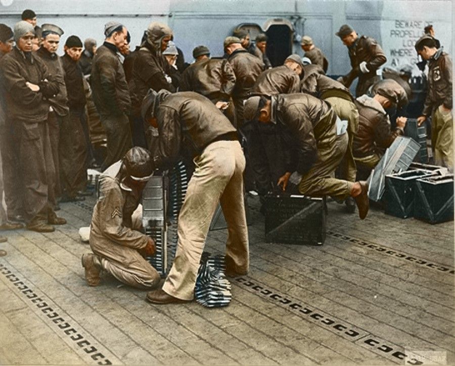 US army personnel in the Doolittle Raid loading ammunition in aircraft guns.
