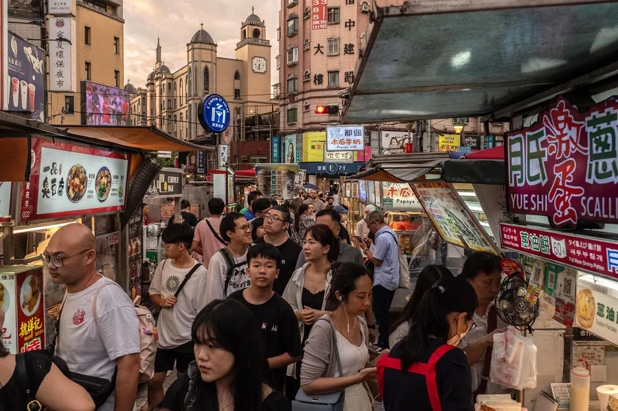 Shoppers pass food stalls at a night market in Taipei, Taiwan, on 8 July 2024. (Lam Yik Fei/Bloomberg)