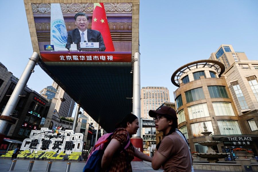 A giant screen broadcasts news footage of Chinese President Xi Jinping attending via video link the meeting of the Shanghai Cooperation Organisation Council of Heads of State, in Beijing, China, 4 July 2023. (Tingshu Wang/Reuters)