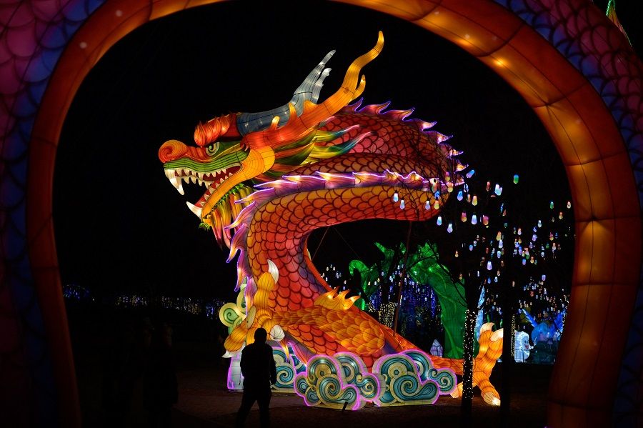 A man walks past a dragon figure at a new year's fair in Beijing, China, on 4 February 2024. (Pedro Pardo/AFP)