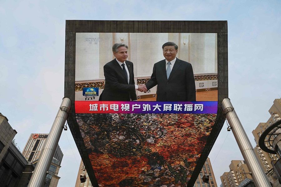 A China Central Television news broadcast shows footage of US Secretary of State Antony Blinken (left) meeting with Chinese President Xi Jinping, on a giant screen outside a shopping mall in Beijing, China, on 19 June 2023. (Greg Baker/AFP)