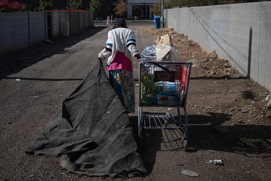 A homeless woman carries her personal belongings in Phoenix, Arizona, on 3 November 2024. (Ernesto Benavides/AFP)