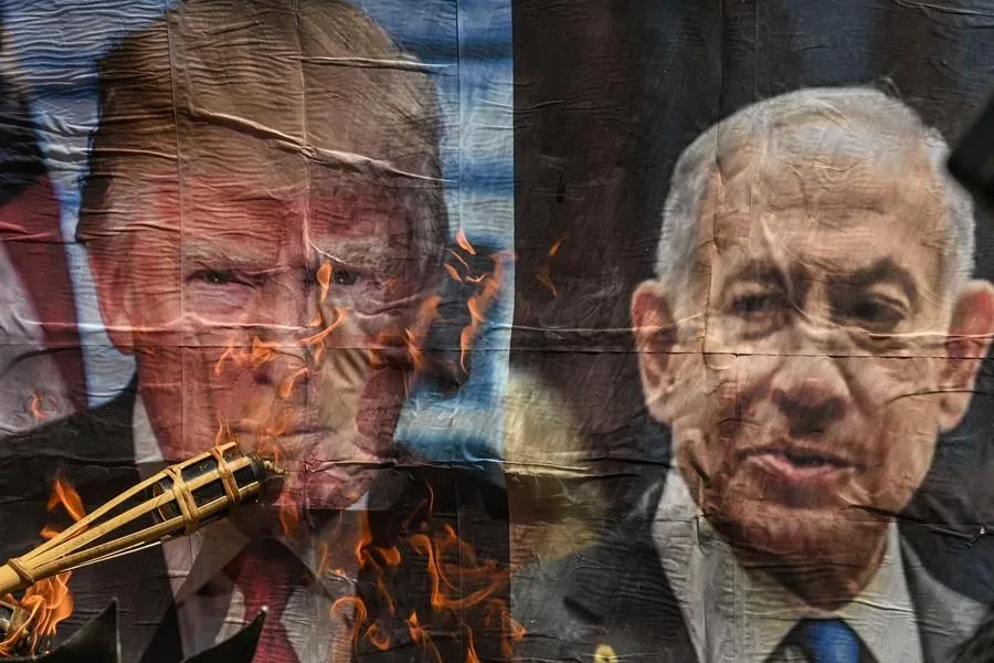 A man burns a picture of US President Donald Trump and Israeli Prime Minister Benjamin Netanyahu during a protest against the US-Israel military action in Iran, near the US Embassy in Manila on 9 April 2026. (Jam Sta Rosa/AFP)