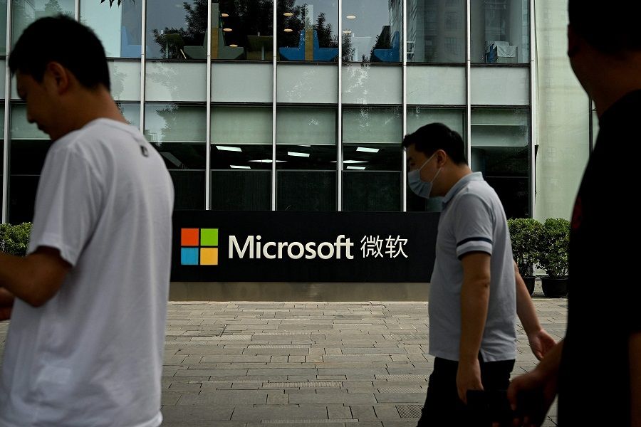 Pedestrians walk past Microsoft's local headquarters in Beijing, China, on 20 July 2021. (Noel Celis/AFP)