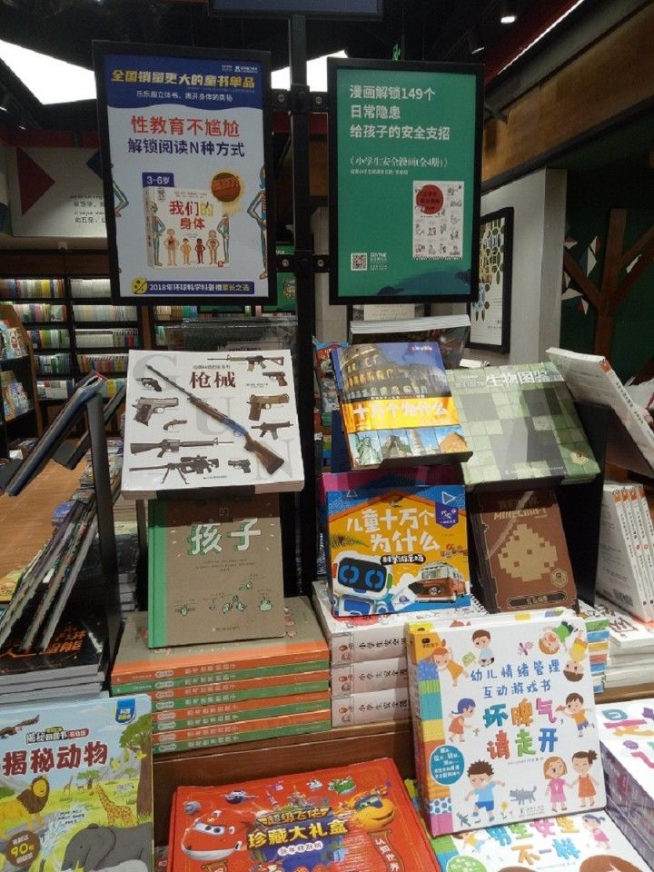 A pictorial encyclopedia of guns is displayed right in the middle of the children's books section in a bookstore.