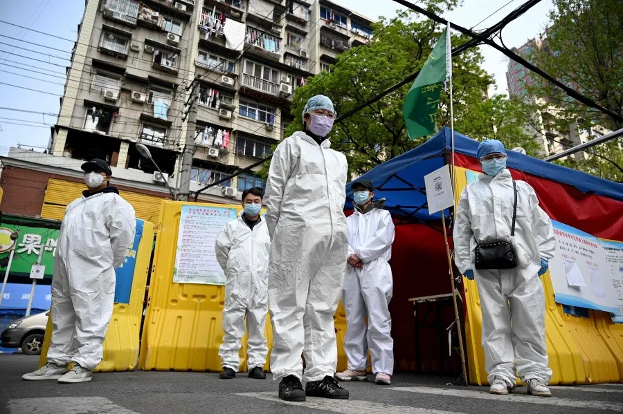 Community volunteers in Wuhan observe three minutes of silence along with the rest of the country, to mourn those who died in the pandemic, April 4, 2020. (Noel Celis/AFP)