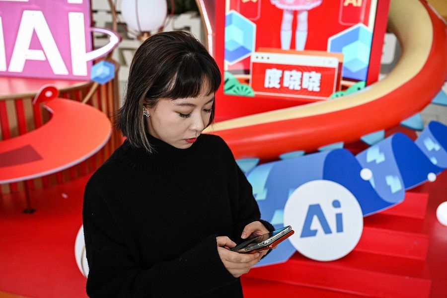 This photo taken on 2 February 2024 shows the head of Product Management and Operations of Wantalk, an artificial intelligence chatbot created by Chinese tech company Baidu, scrolling through virtual character profiles on her phone, at the Baidu headquarters in Beijing, China. (Jade Gao/AFP)