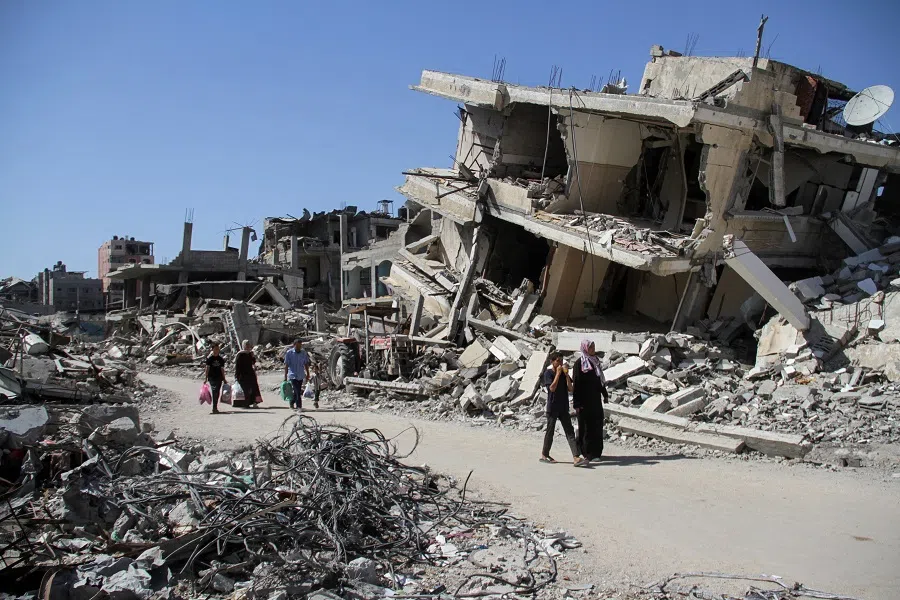 Palestinians walk among the rubble of damaged buildings, which were destroyed during Israel’s military offensive, in Beit Lahia in the northern Gaza Strip on 12 June 2024. (Mahmoud Issa/Reuters)