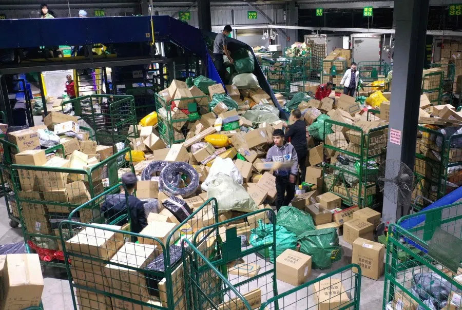 Workers sort packages for delivery at a warehouse of China Post Group in Hengyang, in central China's Hunan province on 12 November 2020, a day after the end of the Singles' Day shopping festival. (STR/AFP)