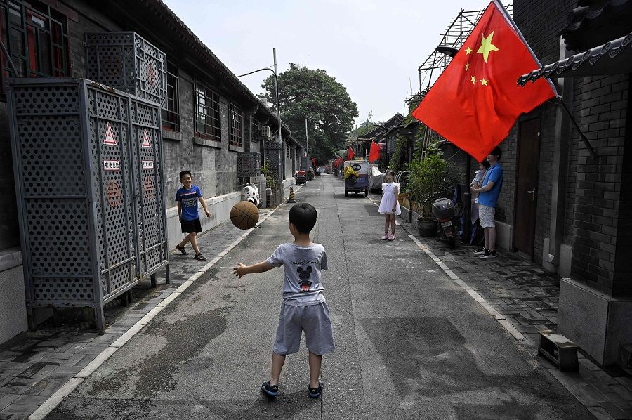 Children play with a basketball in an alley in Beijing, China on 26 June 2021. (Jade Gao/AFP)