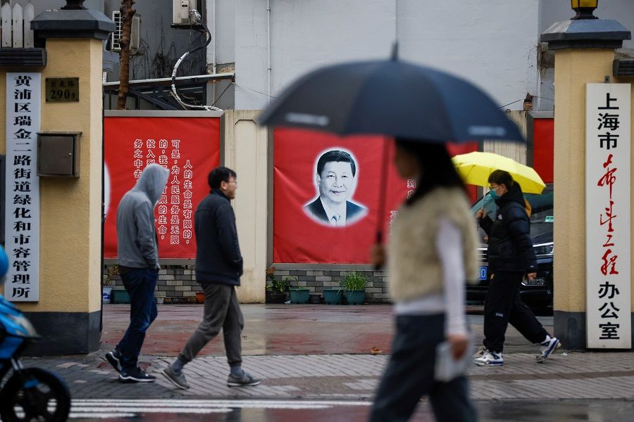 A portrait of Chinese President Xi Jinping hanging on a street wall ahead of the National People's Congress (NPC), in Shanghai, China, 1 March 2021. (Aly Song/Reuters)