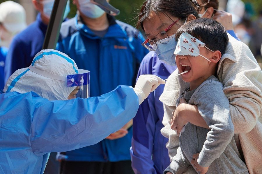 A child receives a swab test for the Covid-19 coronavirus in a compound during a Covid-19 lockdown in Pudong district in Shanghai, China, on 17 April 2022. (Liu Jin/AFP)