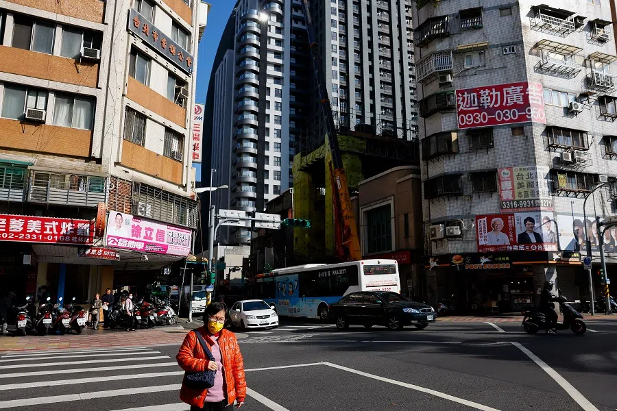 A woman crosses a street in Taipei City, Taiwan, on 2 January 2024. (Ann Wang/Reuters)