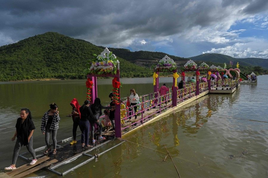 Local tourists walk on a decorated floating stage at a tourist site in Kampong Speu province on 24 October 2021. (Tang Chhin Sothy/AFP)