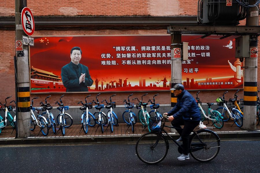 A picture of Chinese President Xi Jinping overlook a street ahead of the National People's Congress (NPC), in Shanghai, China, 1 March 2021. (Aly Song/Reuters)