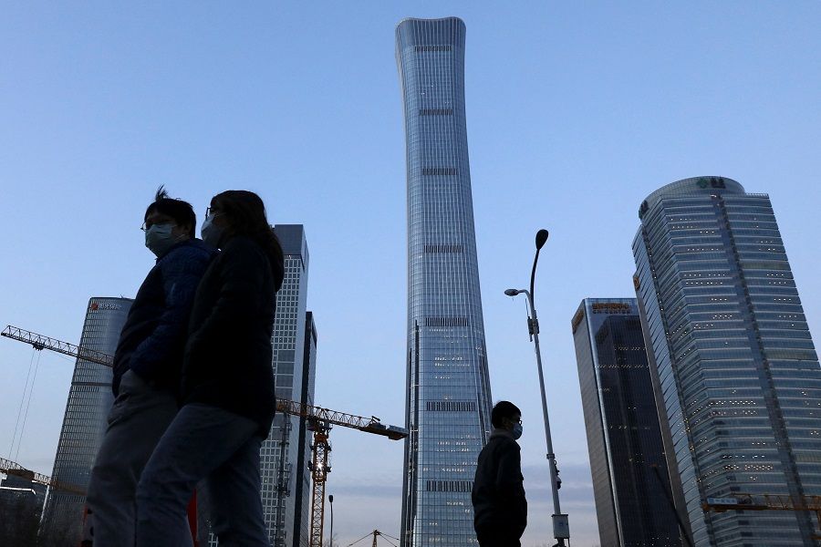 People walk past the central business district in Beijing, China, 16 January 2022. (Tingshu Wang/Reuters)