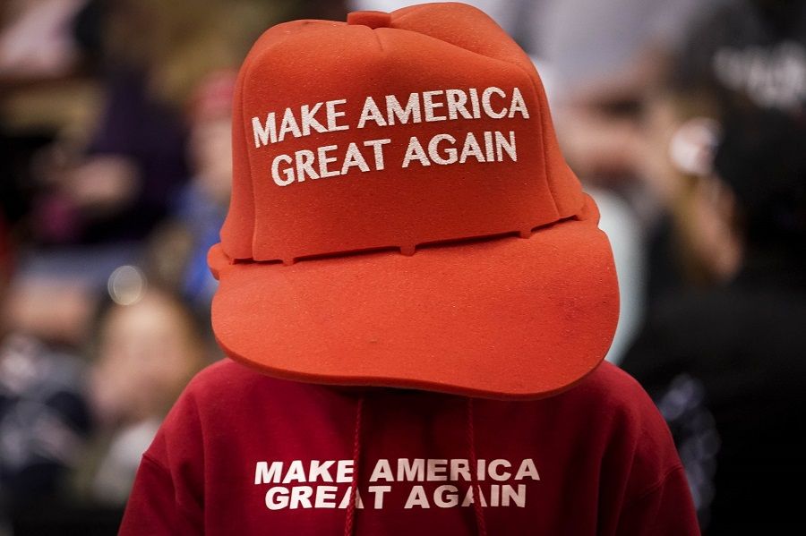 A supporter of US President Donald Trump wears an oversize "Make America Great Again Hat" as he waits for the start of a "Keep America Great" rally at Southern New Hampshire University Arena on 10 February 2020 in Manchester, New Hampshire. (Drew Angerer/Getty Images/AFP)