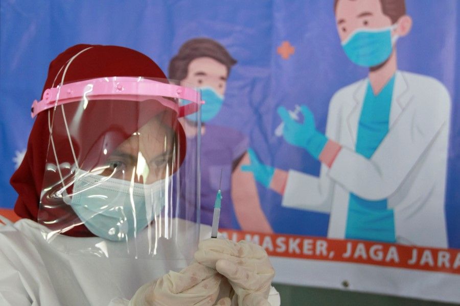 A health care worker prepares a dose of China's Sinovac Biotech vaccine for the coronavirus disease (Covid-19), during a mass vaccination for vendors at the Tanah Abang textile market in Jakarta, Indonesia, 17 February 2021. (Ajeng Dinar Ulfiana/Reuters)