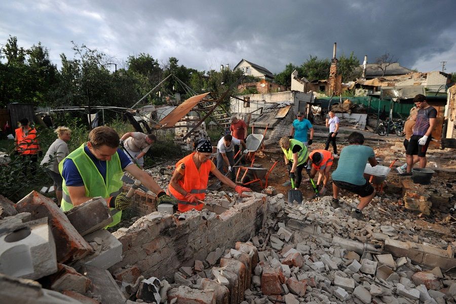Volunteers clear the rubble of a house destroyed as a result of the shelling in the city of Chernihiv on 19 August 2022, amid Russia's invasion of Ukraine. (Sergei Chuzavkov/AFP)